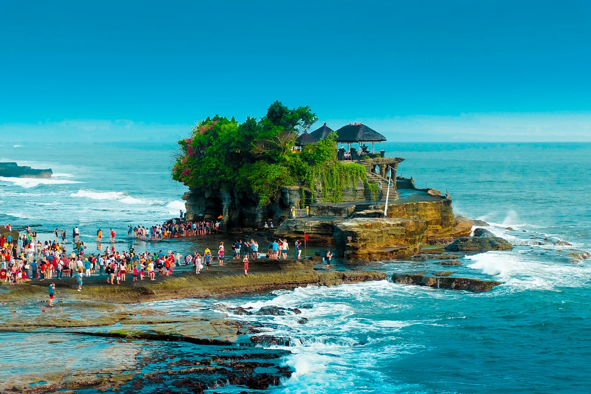 Visitors on the rocks at low tide below Tanah Lot, Bali's sea temple