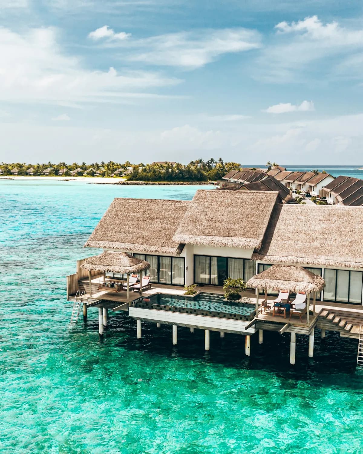 Overwater villas on a clear turquoise lagoon in the Maldives