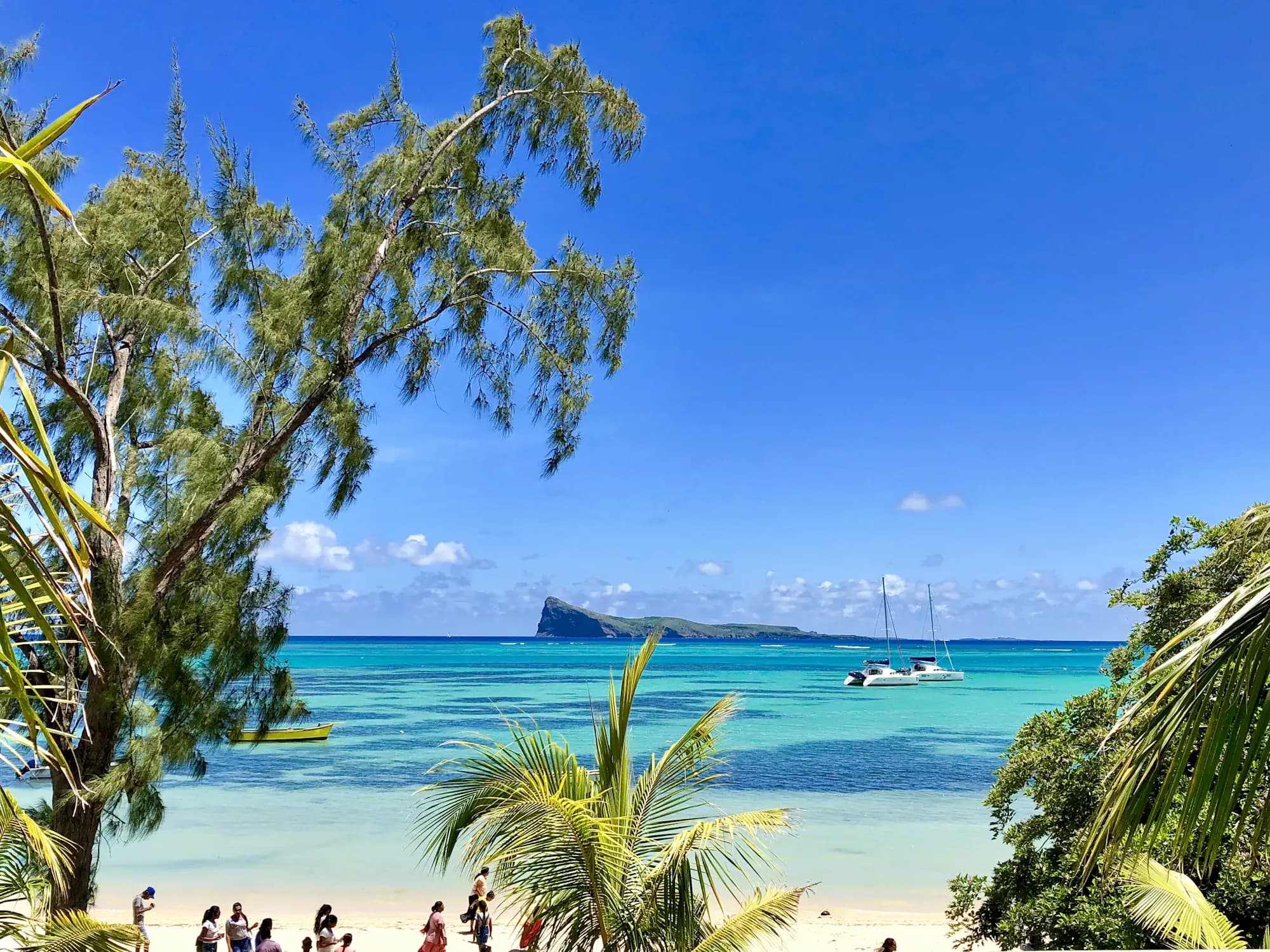 People on Bain Boeuf beach, Grand Baie, looking out to Coin de Mire