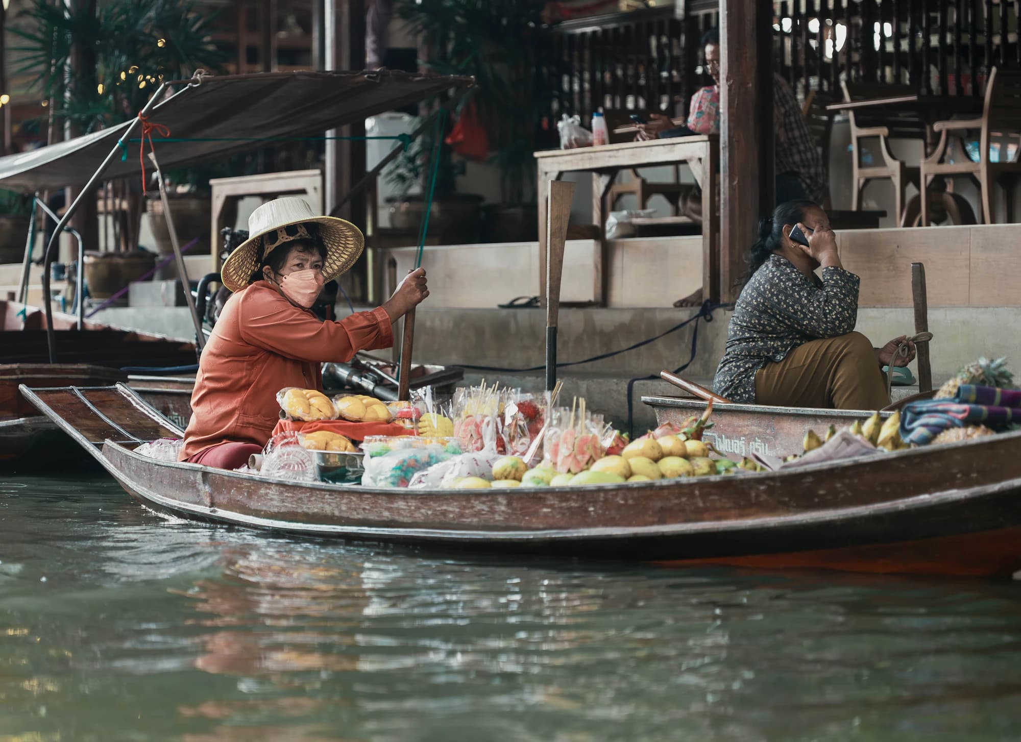 A vendor selling fruit from her boat at a floating market