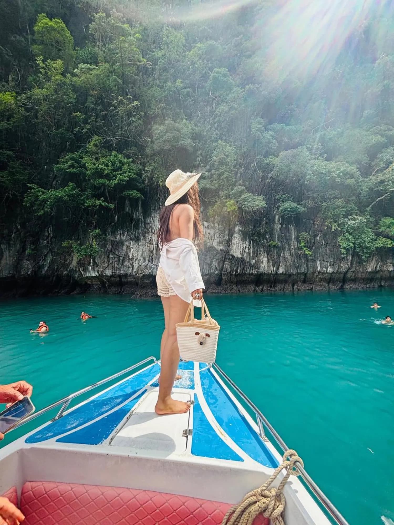On the bow of a longtail boat in a Phi Phi lagoon