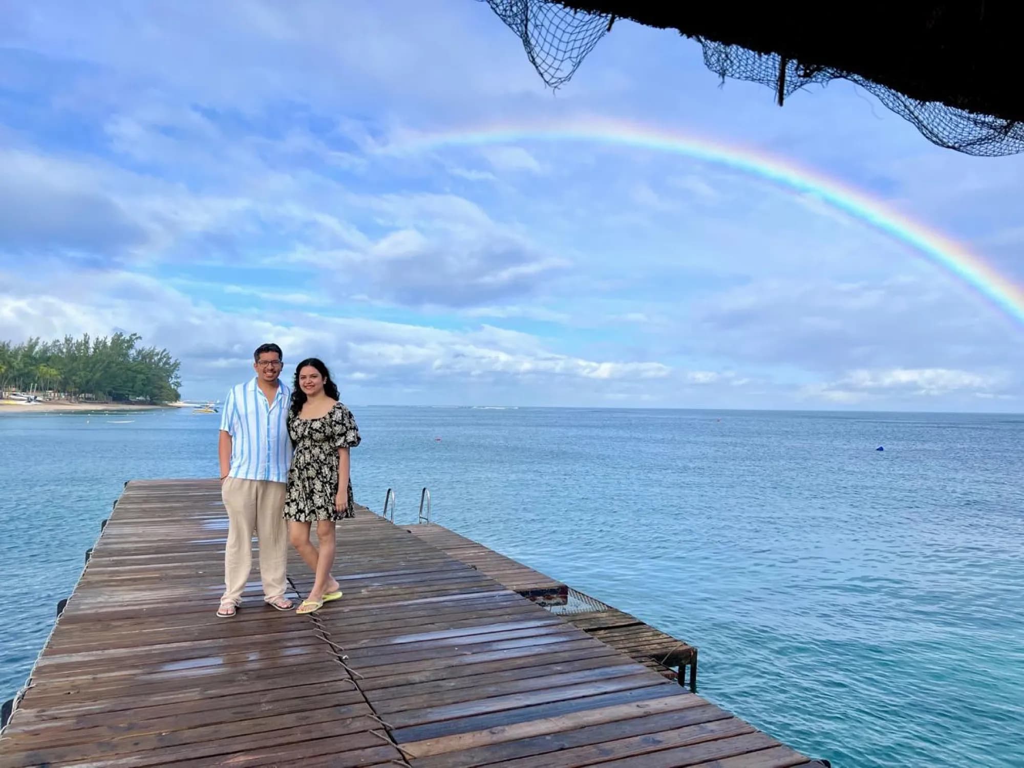 A couple on a pier under a rainbow, Mauritius
