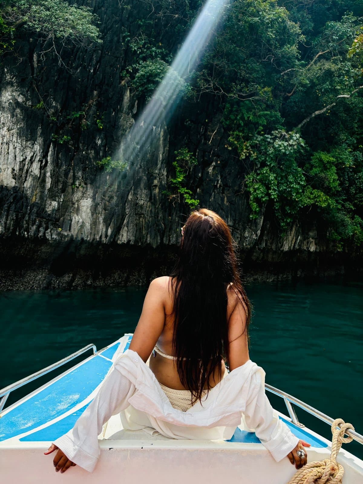 On the bow of a longtail boat in a Phi Phi lagoon