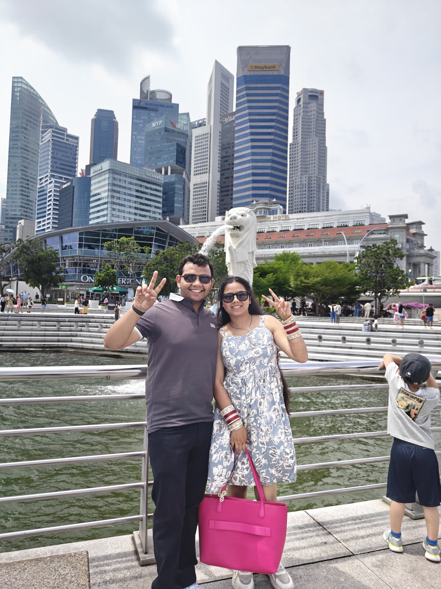 A couple at the Merlion with the Marina Bay skyline behind