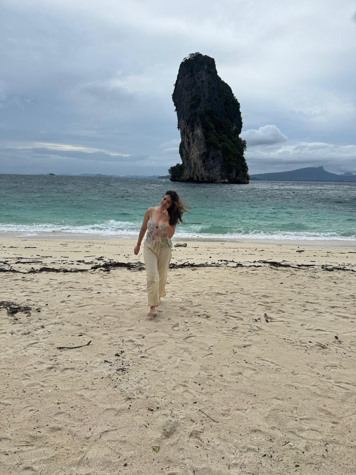 Walking the beach towards a limestone sea stack, Thailand