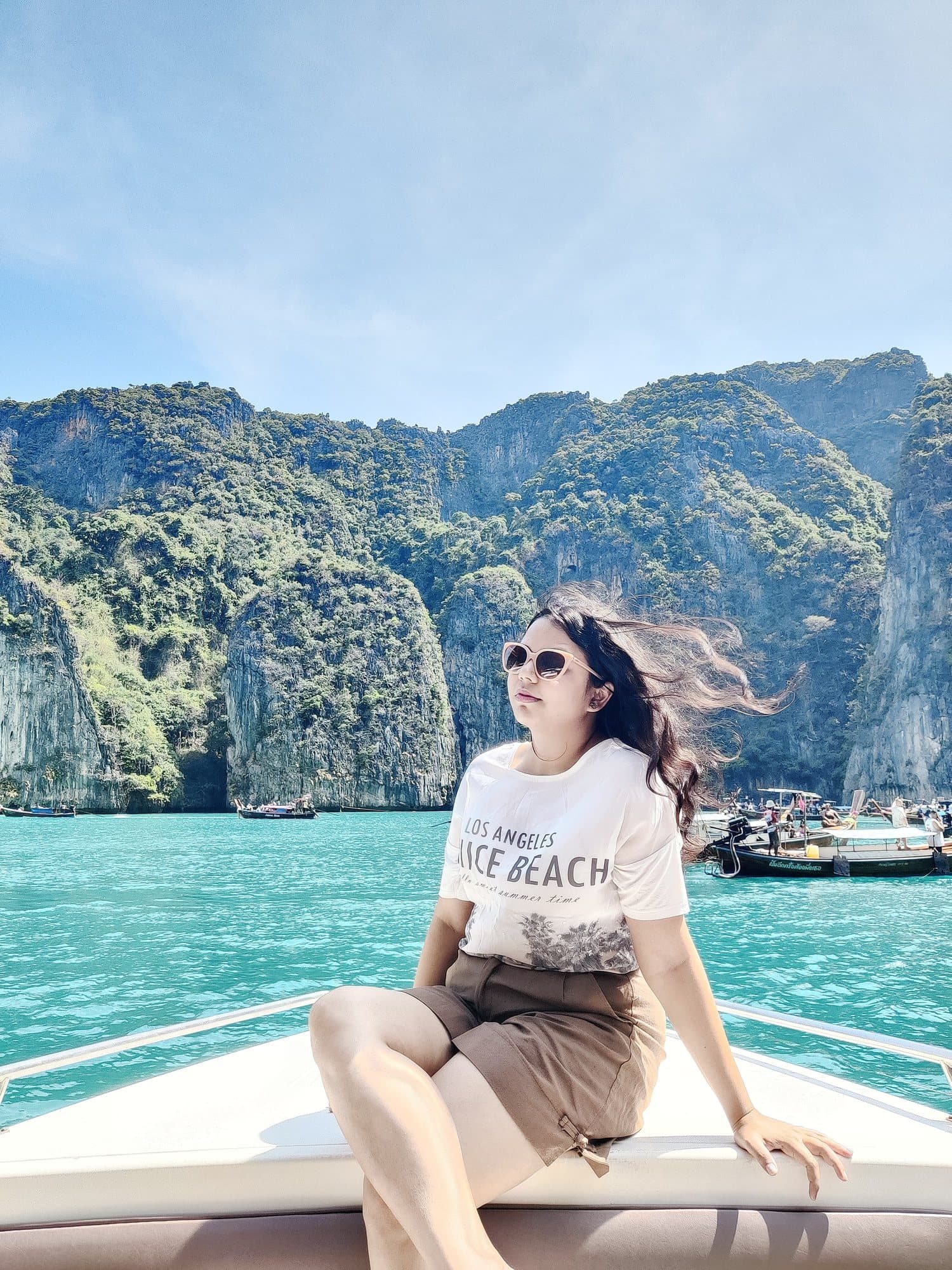 On a boat below limestone cliffs, Thailand