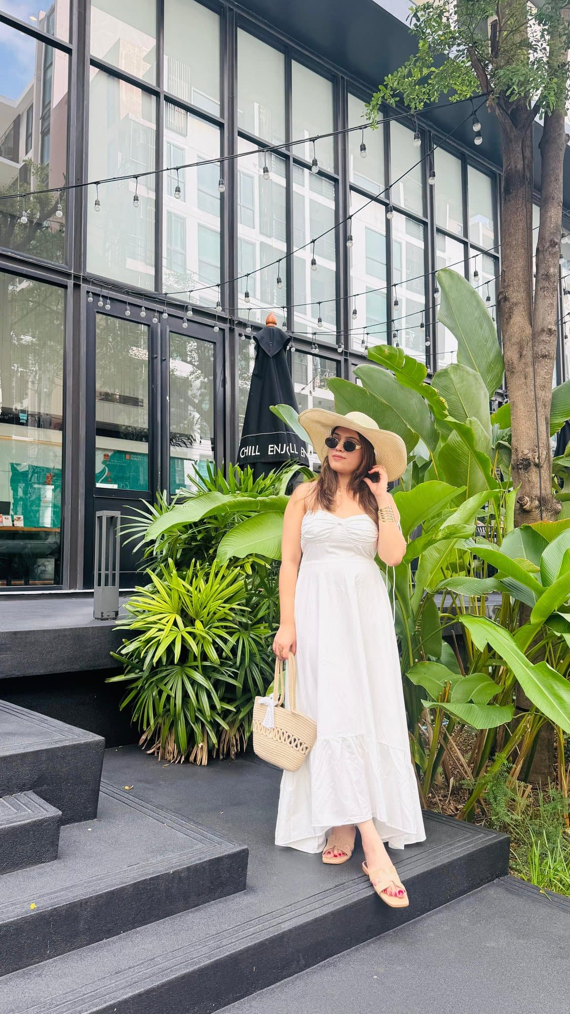 In a white dress on a hotel's garden steps, Thailand