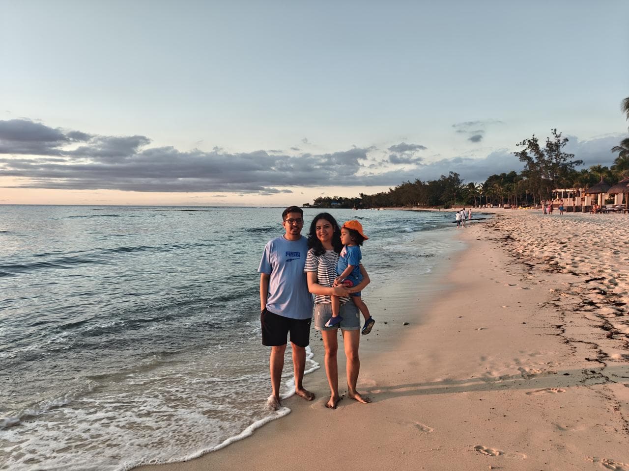 Parents and their toddler on the beach at sunset, Mauritius