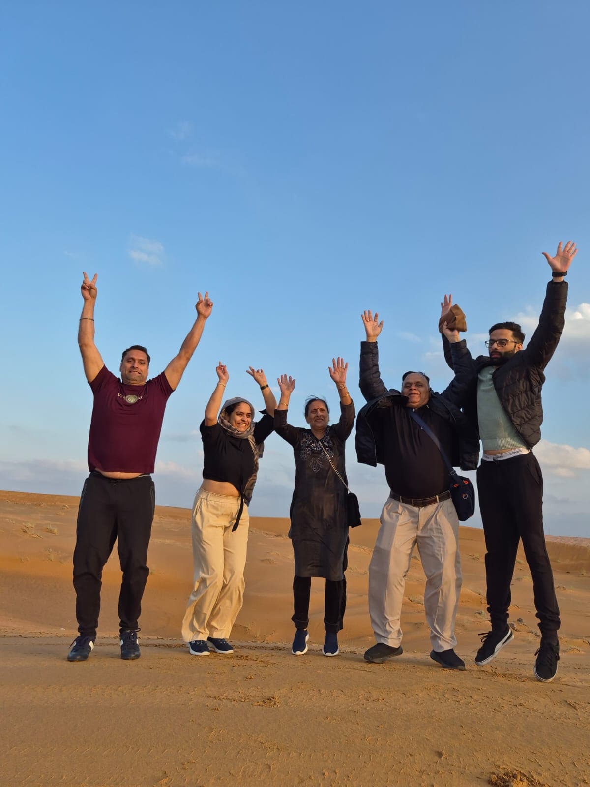 A family jumping on the desert dunes near Dubai